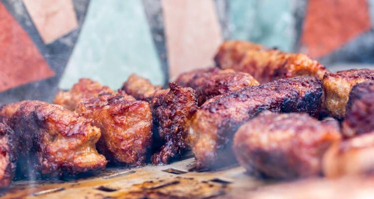 Grilled meat in a traditional setting with colorful tiles.