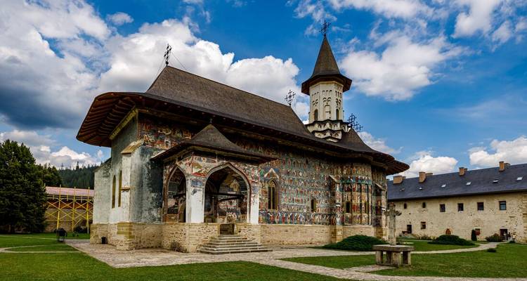 Historic painted monastery with ornate artwork on the walls.