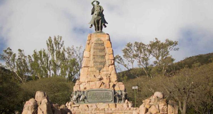 Standbeeld van een man te paard op een stenen sokkel met inscripties.