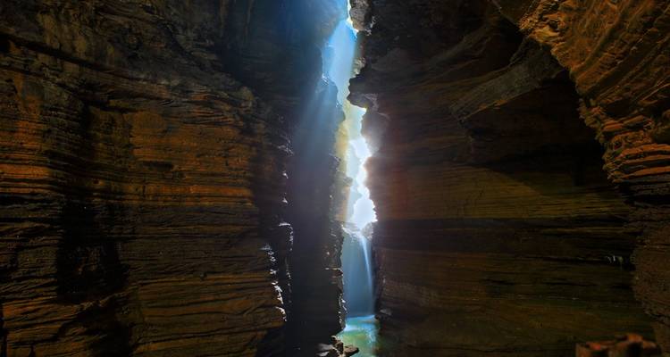 Dramatic cave interior with light seeping through openings.