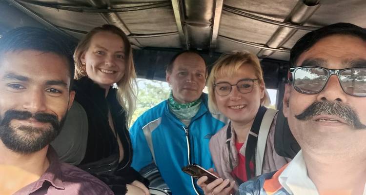 Cinq personnes prenant un selfie à l'intérieur d'un véhicule.