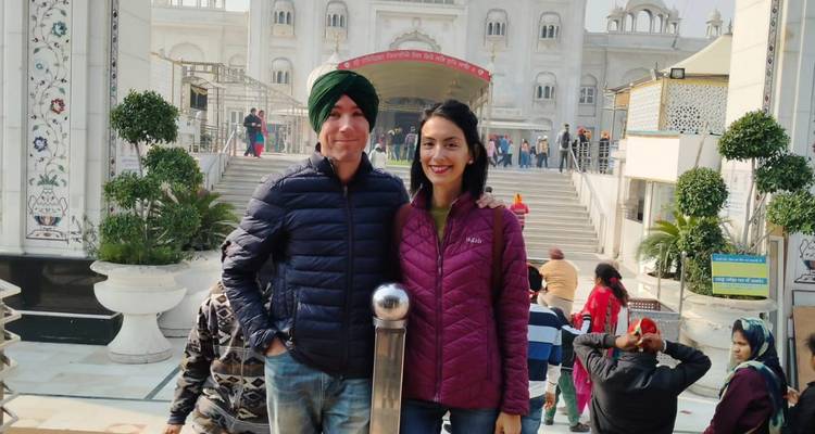 Couple in front of a temple entrance, dressed for visiting sacred sites.