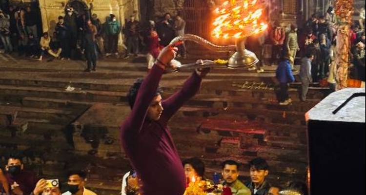 Abendliche Ritualzeremonie mit einem Priester, der eine Lampe hält.