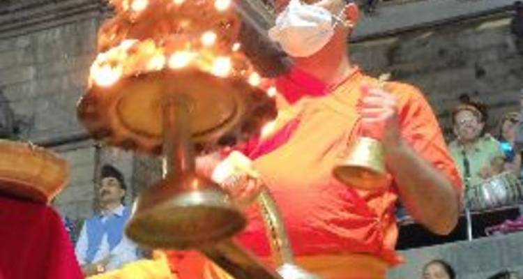 Person, die Aarti-Ritual mit einer brennenden Lampe durchführt.