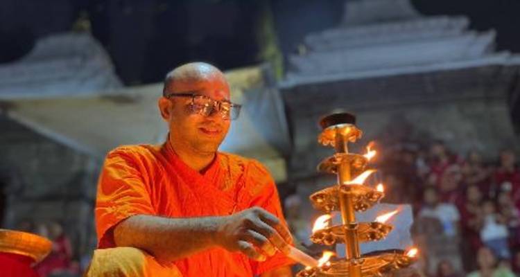 Priester zündet eine Lampe während einer Zeremonie in der Nacht an.