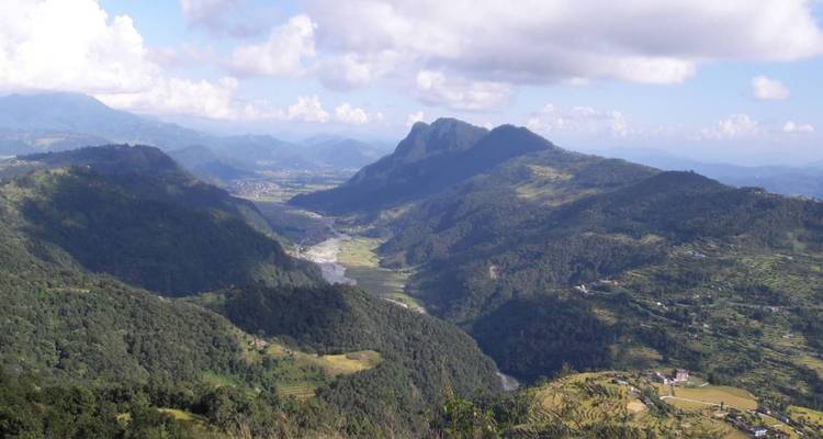 Vue de vallée avec montagnes et rivière au loin