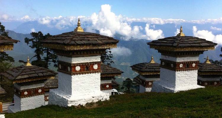 Stupas mit schneebedeckten Bergen im Hintergrund.