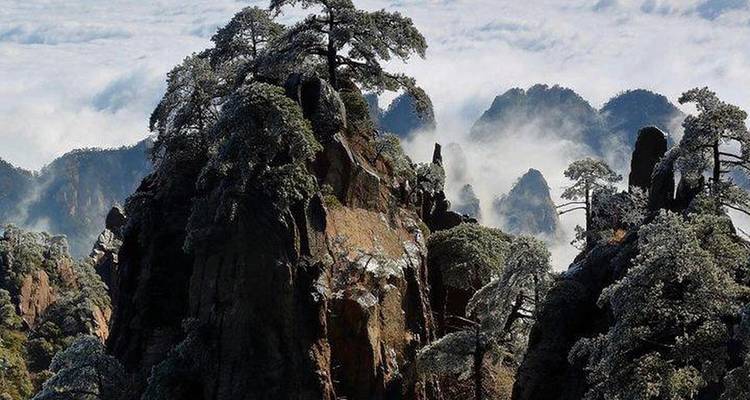 Rock formations covered in snow and mist.