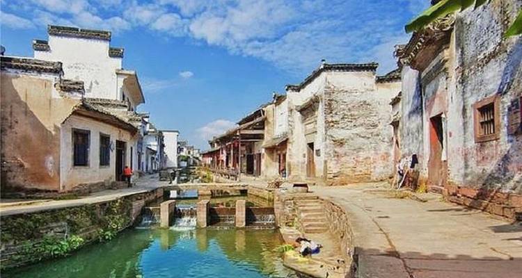 Traditional village street with canal and vibrant buildings.