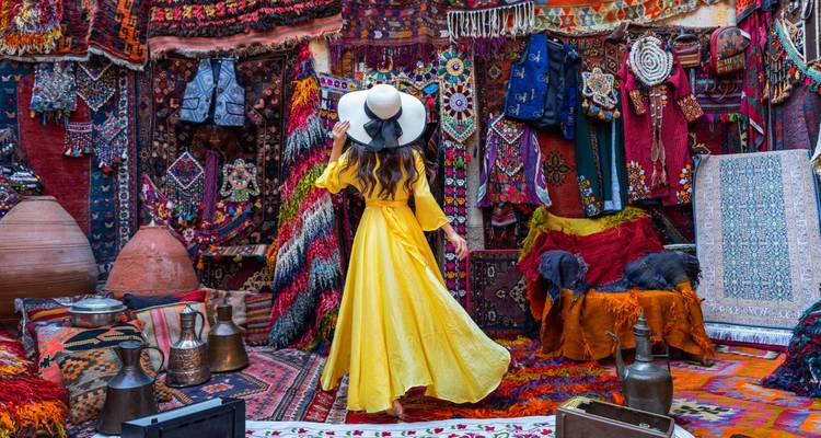 Woman in a yellow dress in a colorful market.
