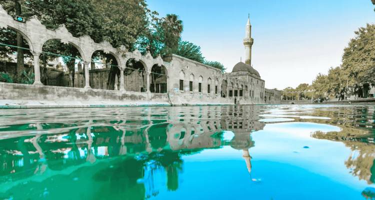 Building reflection in a turquoise pool with arches.