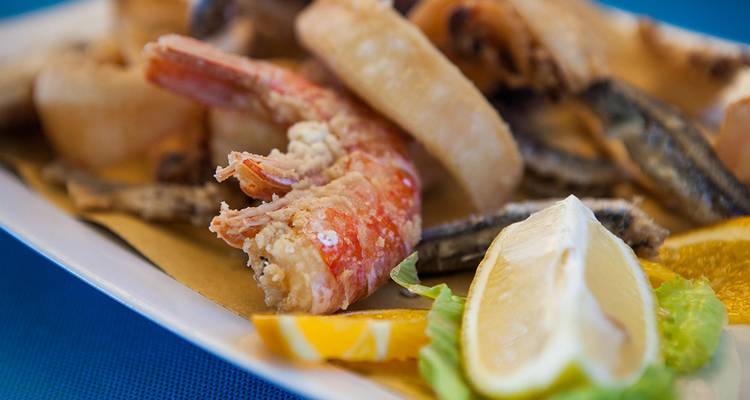 Close-up of a seafood platter with lemons and fried items.