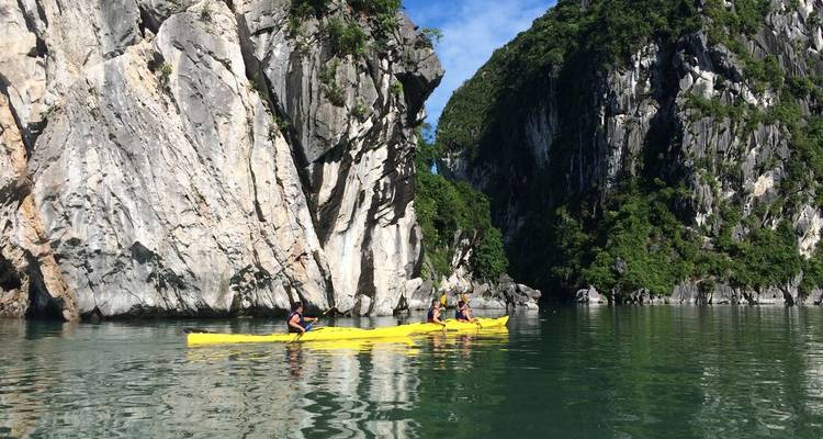 Des kayakistes explorant une magnifique baie entourée de falaises.