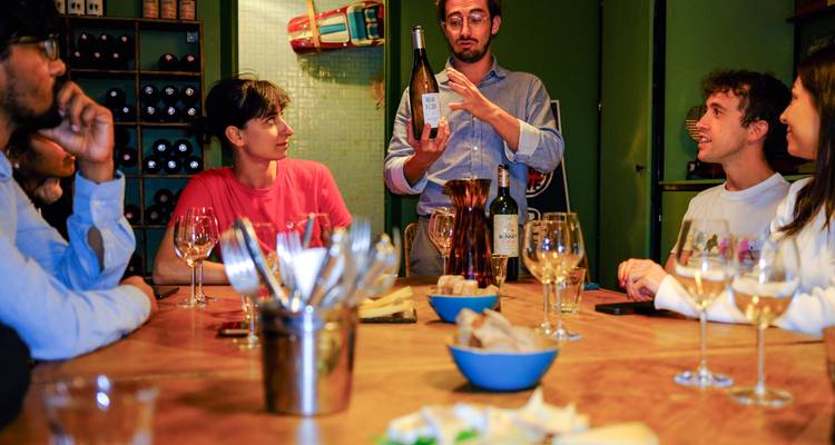 Événement de dégustation de vin avec des personnes assises autour d'une table avec des verres de vin.