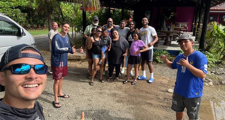 Un groupe de personnes posant pour une photo à l'extérieur près d'un espace de repos couvert.