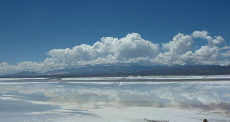 Zoutvlaktes met reflecterend oppervlak onder blauwe luchten