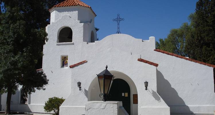 Witte adobe kerk met een kruis bovenop