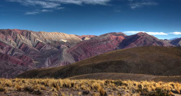 Kleurrijke gestreepte bergen onder een blauwe hemel.