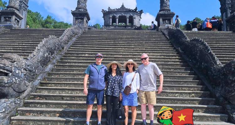Cuatro turistas en la gran escalinata de piedra que conduce a la tumba del Emperador Khai Dinh.