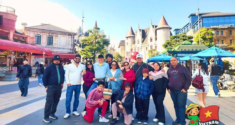 Grupo de turistas reunido en una plaza de pueblo de estilo europeo en Ba Na Hills.