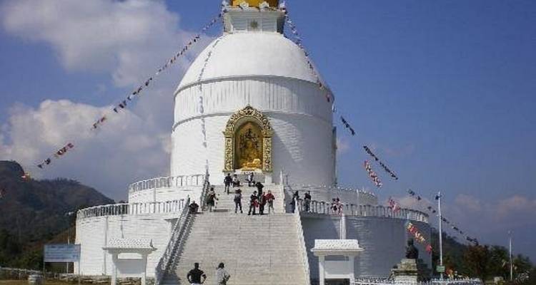 Pagoda de la Paz Mundial con visitantes en los escalones contra un cielo despejado.