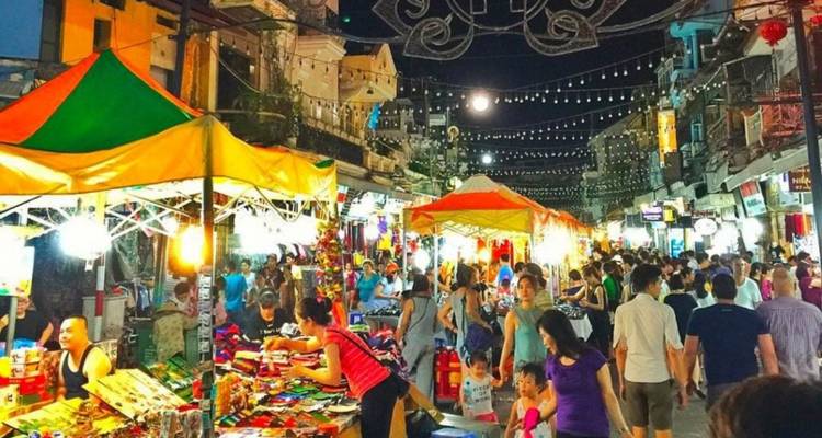 Night market scene with lively crowds and colorful stalls.