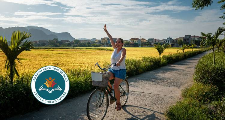 Person cycling on a path through a field.