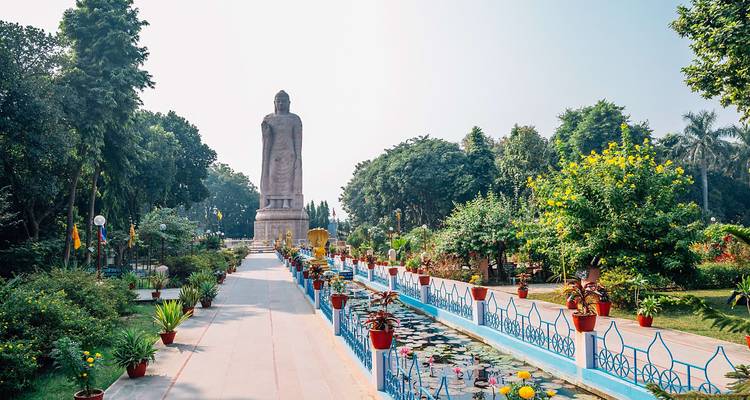 Große Buddha-Statue umgeben von Gärten.