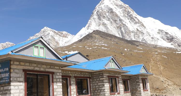 Stone buildings with snowy mountains in the background.