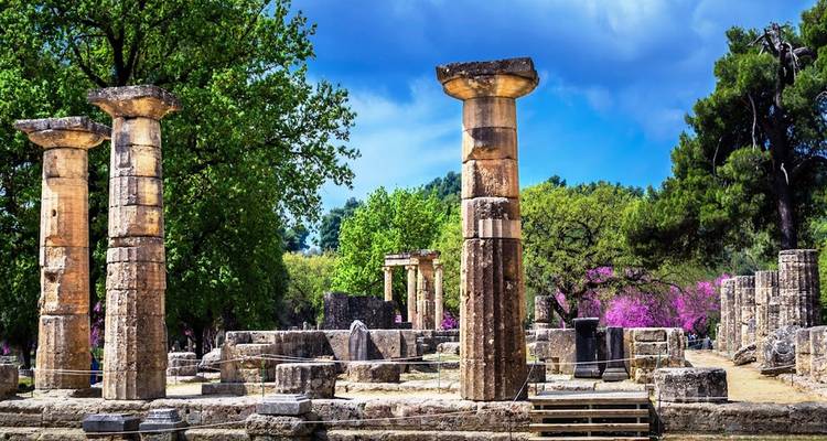 Anciennes colonnes de pierre entourées d'arbres dans un site historique.