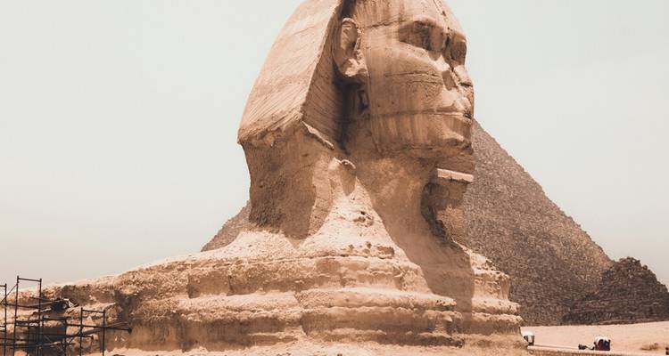 Gros plan du Grand Sphinx avec une pyramide partiellement visible.