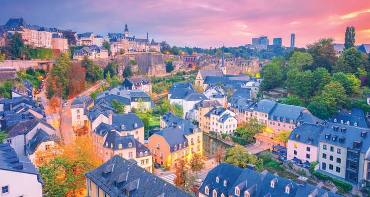 La ville de Luxembourg au coucher du soleil avec des couleurs vibrantes.