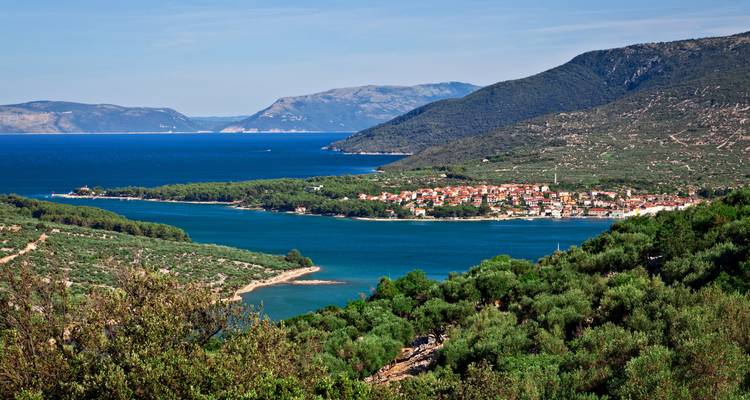 Vue panoramique d'une ville côtière et d'un paysage avec des eaux bleues.