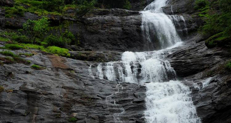 Cascade d'eau qui dégringole sur un terrain rocheux.