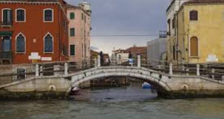 Pont de pierre au-dessus d'un canal avec des bâtiments de chaque côté.