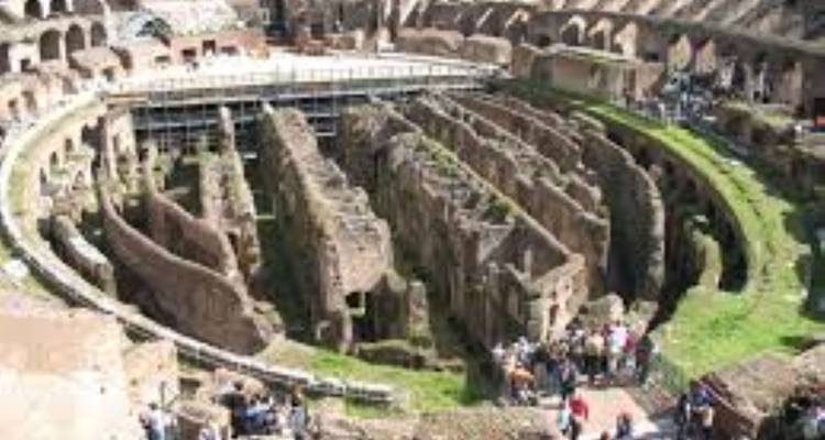 Ruines du Colisée avec des touristes à l'intérieur.