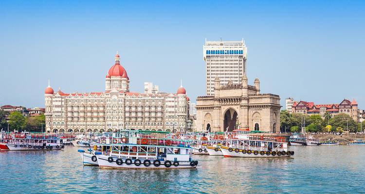 View of Mumbai's harbor with boats and iconic architecture.