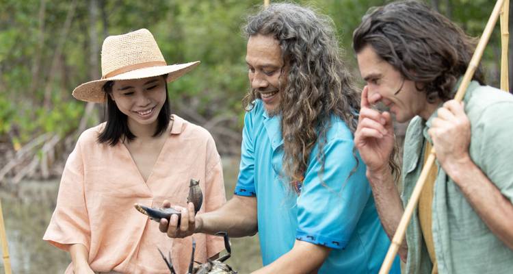 Grupo aprendiendo habilidades tradicionales en una playa.