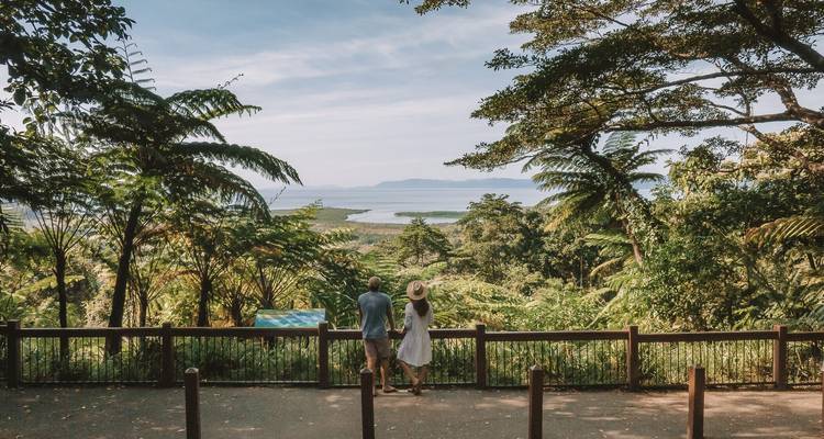 Pareja disfrutando de un mirador sobre exuberante selva tropical hacia la costa e islas
