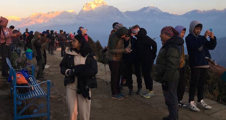 Groupe de touristes à un point de vue avec des montagnes en arrière-plan.