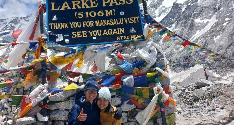 Two people posing at Larke Pass with prayer flags.