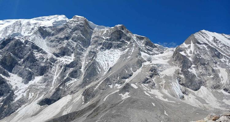 Rocky snowy mountains with clear blue skies.