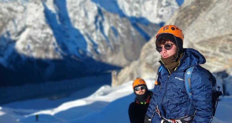 Hikers in cold weather gear with snowy mountains behind them.