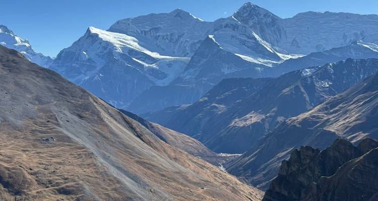Mountain landscape with snowy peaks under a clear blue sky.