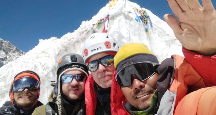 Group selfie in snowy mountains with colorful attire.
