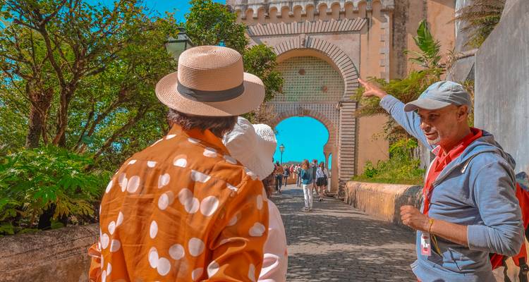 Tourist guide showing a historical archway to visitors.