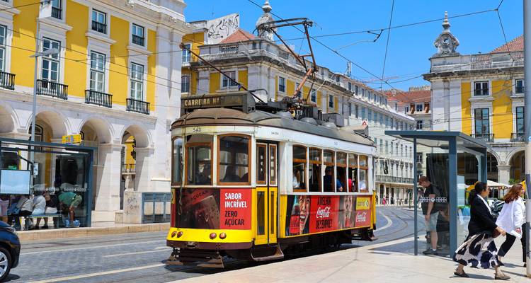 Vintage tram with advertisements in a city square.