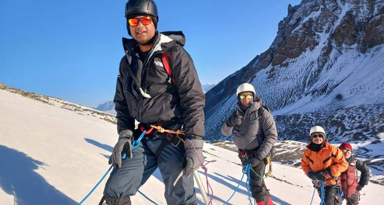 Group of climbers with gear on a snowy mountain in Nepal.