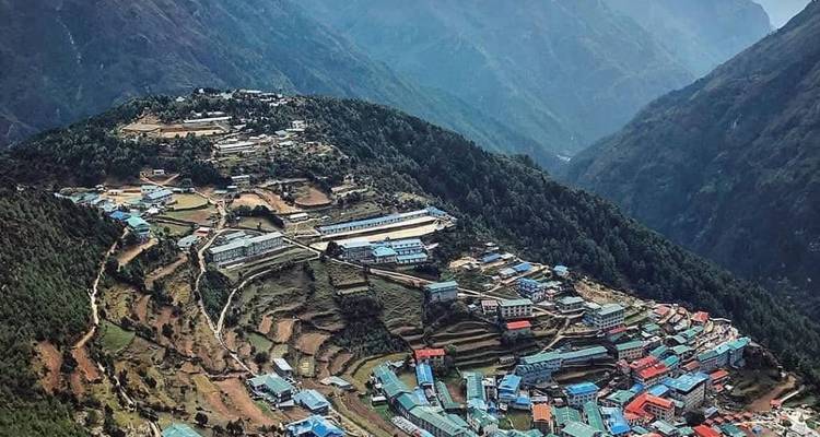 Aerial view of a village in a mountainous region, likely in Nepal.