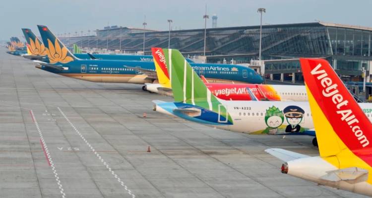 Plusieurs avions de différentes compagnies aériennes stationnés à un terminal d'aéroport.
